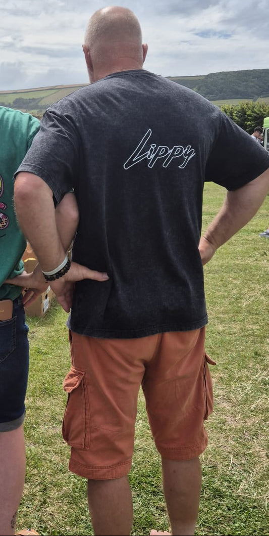 Person wearing a black t-shirt with 'Lippy' printed on the back, standing outdoors.